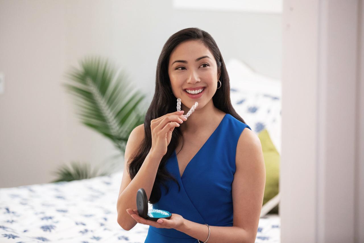 Patient holding a clear Invisalign aligner